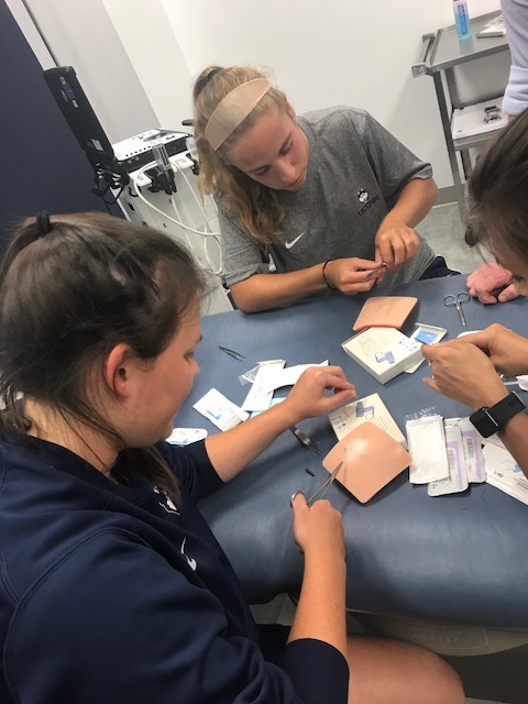 students cutting bandages