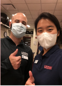 man and woman from UConn Athletic Training wearing masks and giving thumbs up